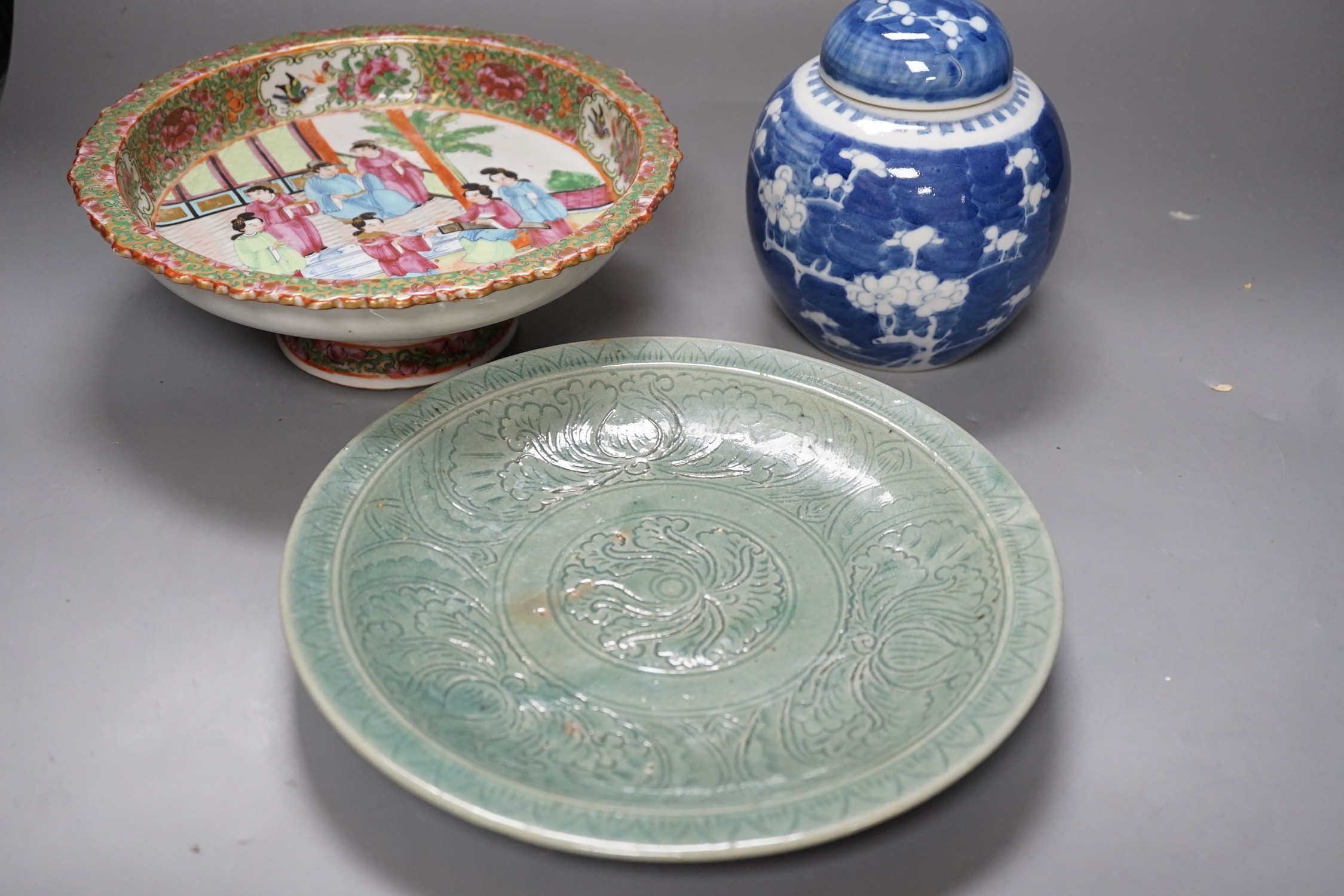 A Chinese famille rose pedestal dish, 23cm, a Thai celadon dish and a blue and white prunus jar and cover.